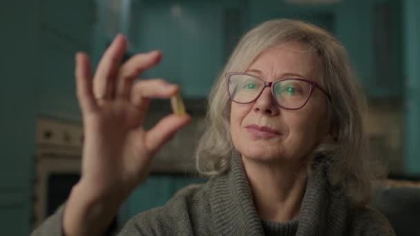 高级妇女手拿着胶囊 六十多岁的女人照顾健康 欧米茄 3鱼油对老年人来说非常健康 — 图库视频影像