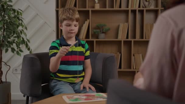 Szkolny Chłopiec Rozwiązujący Drewniane Puzzle Wędkarskie Siedzący Gabinecie Terapeuty Świadomość — Wideo stockowe