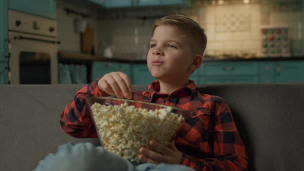 Niño Comiendo Palomitas Viendo Televisión Colegial Disfruta Merienda Sentado Sofá — Vídeo de stock