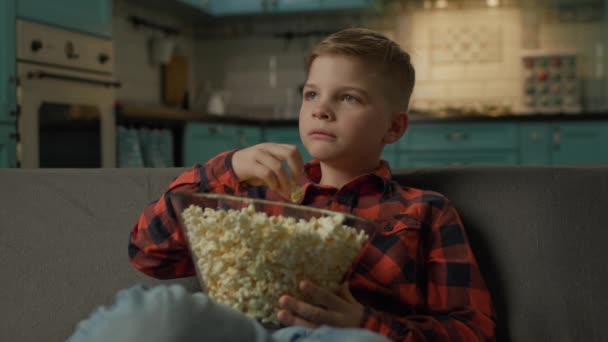 Chłopiec Jedzący Popcorn Oglądający Telewizję Dziecko Lubi Przekąski Siedząc Kanapie — Wideo stockowe