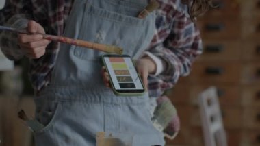 Artist Using Mobile Phone For Preparing Paints. Female painter creating artworks in workshop. 4K