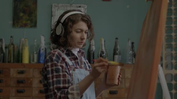Cheerful Artist Creating Her Masterpiece Listening Music Female Painter Headphones — Vídeo de stock
