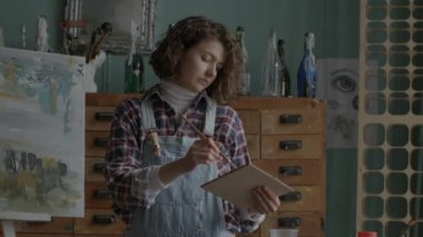 Painter Creating Masterpiece. Female artist drawing in workshop. Woman working in art workspace. 4K