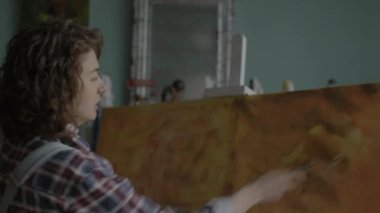 Woman Creating Her Masterpiece Close Up. Female artist painting on canvas in workshop. Woman working in art workspace. 4K