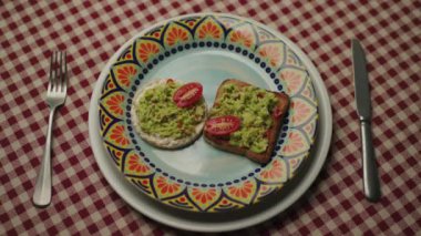 Avokado 'yu tostla mı yoksa fitness ekmeğiyle mi seçiyorsun? Avokado soslu bir parça fitness ekmeği alan kişi. Sağlıklı kahvaltı. 4K
