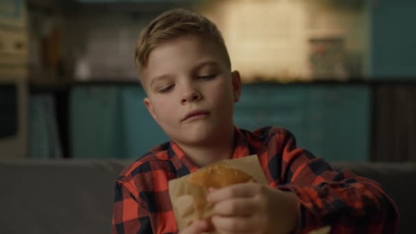 Child Eats Burger Looking Camera Hungry Boy Eating Fast Food — Vídeo de Stock