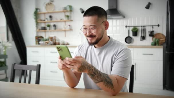 Homme Souriant Textos Aide Téléphone Portable Maison Asiatique Homme Bavarder — Video