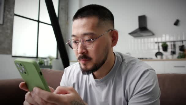 Homme Souriant Textos Aide Smartphone Maison Fermer Coréen Homme Bavarder — Video