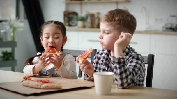 Két Gyerek Pizzát Eszik Otthon Többnemzetiségű Gyerekek Együtt Esznek Pizzát — Stock videók