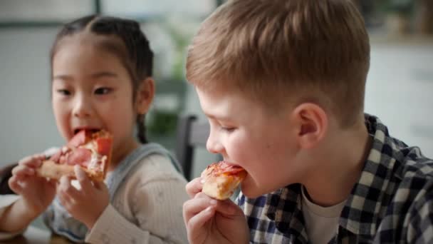 Duas Crianças Multiétnicas Comer Pizza Perto — Vídeo de Stock