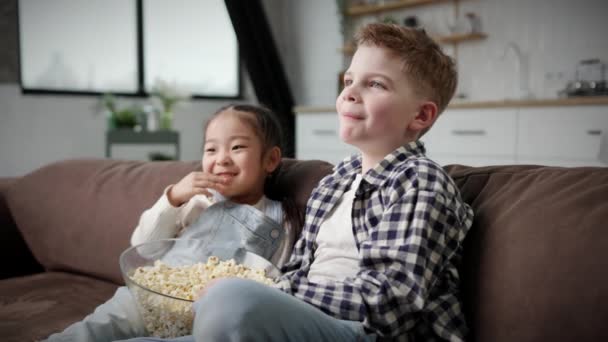 Multi Etnische Kinderen Die Popcorn Eten Zittend Bank Kleine Meid — Stockvideo