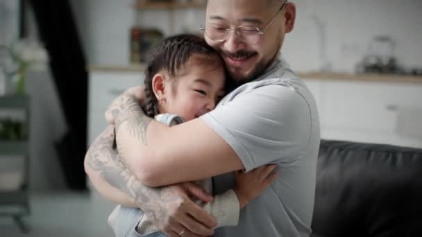 爱爸爸拥抱他的女儿 快乐的亚洲父亲和女孩拥抱和亲吻坐在家里 — 图库视频影像