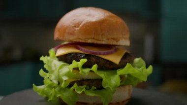 Double Cheeseburger ağır çekimde dönüyor. Büyük sulu Burger yakın çekim. 