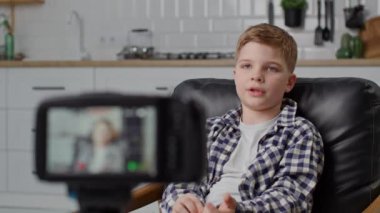 Boy Records Video Blog On Camera. Genç blogcu tripodla kameraya konuşuyor. Yakın çekim. 4K