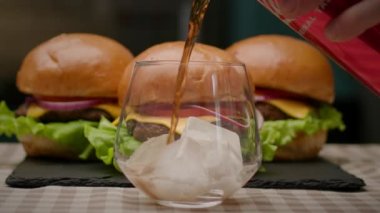 Kola buzla bardağa doluyor. Soğuk içecekle servis edilen burgerler. Ağır çekim. Tam HD
