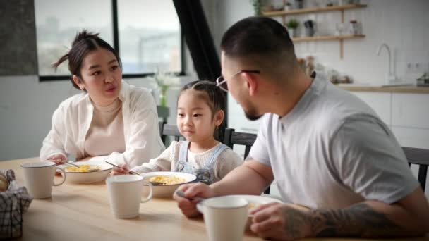 Asiatisk Familie Spiser Morgenmad Derhjemme Lille Pige Spiser Cornflakes Med – Stock-video