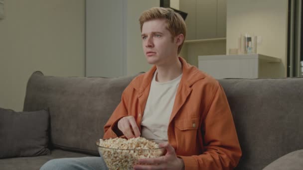 Blonďák Popcorn Sedí Doma Pohovce Mladý Dospělý Muž Dívá Televizi — Stock video