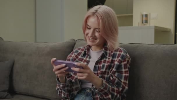 스마트 폰으로 비디오 게임을 여성들은 집에서 소파에 전화로 게임을 — 비디오