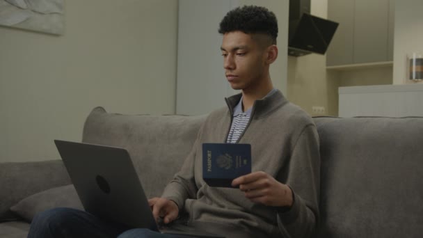 Hombre Negro Escribiendo Ordenador Portátil Que Sostiene Pasaporte Los Estados — Vídeos de Stock