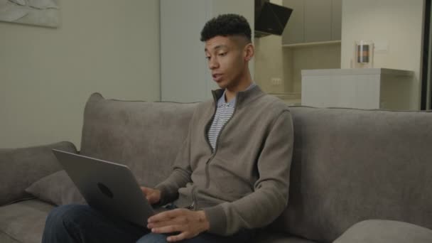 ラップトップを使用したビデオ通話の男 アフリカ系アメリカ人の男性が自宅のオフィスで働いているコンピュータと話している — ストック動画