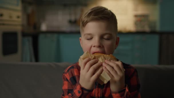 Hungry Kid Eet Hamburger Kijkend Naar Camera Schooljongen Kauwt Fast — Stockvideo