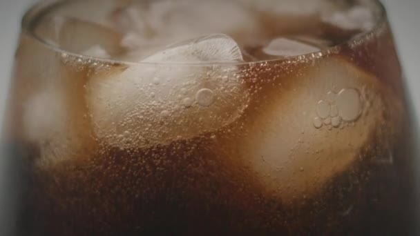 アイスキューブでガラスに注ぐコーラが閉じます 冷たい飲料のソーダ泡 フルHd — ストック動画
