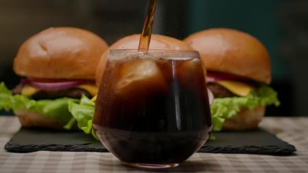 Cola Mit Eis Ins Glas Gießen Burger Mit Kaltgetränk Zeitlupe — Stockvideo