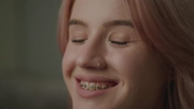 Diş telli, gülümseyen portresi olan 20 'li yaşlarda bir kadın. Kameraya bakan güzel bir milenyum kadını. 4K