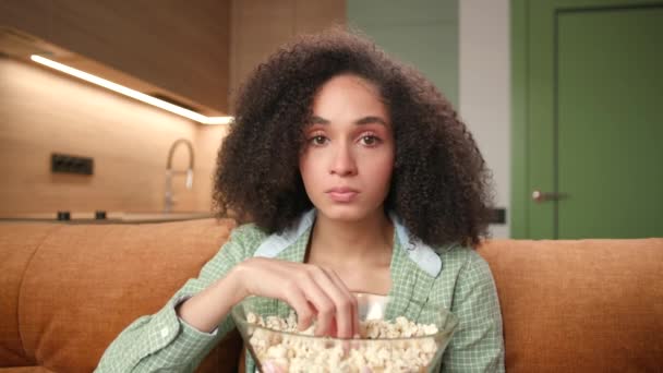 Een Bange Vrouw Die Popcorn Eet Terwijl Naar Camera Kijkt — Stockvideo