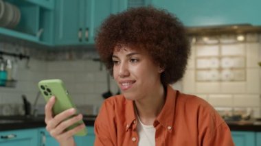 Yemek yerken akıllı telefon kullanan siyah kadın. Gadget bağımlısı insan internette geziniyor. Yakın çekim. 4K