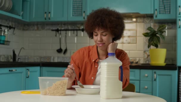 黑人妇女吃玉米片与牛奶早餐 千禧年女性喜欢独自在厨房吃早餐 — 图库视频影像