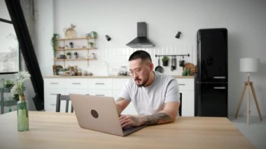 Adam laptoptan kötü haberler alıyor. Asyalı 30 'lu yaşlarda üzgün bir adam evde yalnız başına oturmuş üzücü bilgiler okuyor. 4K