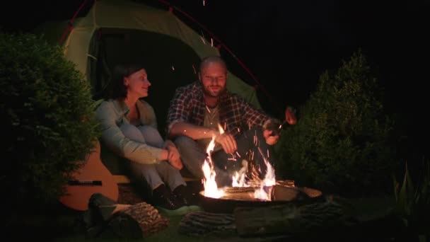 Geceleri Kamp Ateşinin Yanında Çadırda Oturan Çift Konuşuyor Gitarlı Aile — Stok video