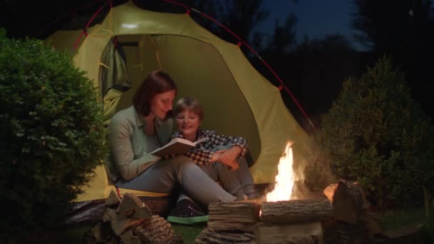 Mutter Liest Ihrem Kind Lagerfeuer Ein Buch Vor Familiencamping Abend — Stockvideo