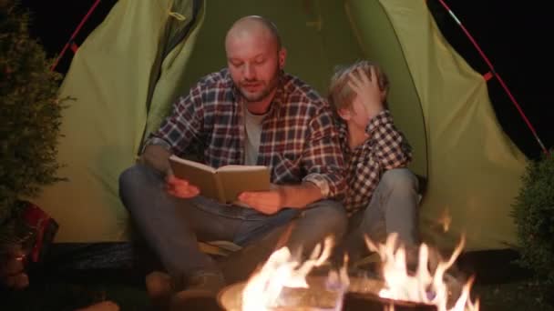Papai Lendo Livro Para Miúdo Adormecido Sentado Tenda Perto Fogueira — Vídeo de Stock