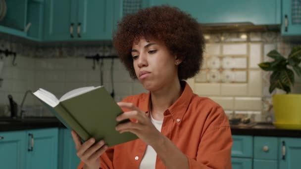 非洲裔美国妇女阅读书籍的特写 千禧年女性喜欢坐在家里看书 喝咖啡看书 — 图库视频影像
