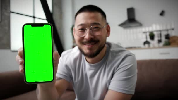 Sonriente Hombre Asiático Mostrando Pantalla Verde Del Teléfono Móvil Cámara — Vídeos de Stock