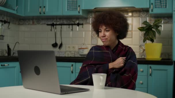 在笔记本电脑上看肥美电影的黑人妇女 女性喜欢坐在寒冷的家里看她最喜欢的系列片 — 图库视频影像