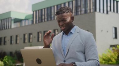 Siyah İşadamı 'nın baş ağrısı laptopta çalışıyor. Açık havada oturan Afrika kökenli Amerikalı erkek migrenden muzdarip. 4K