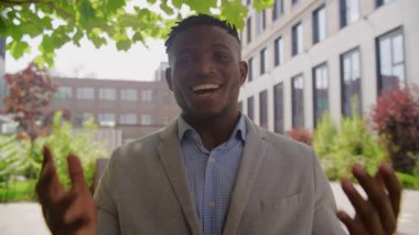Dışarıdaki kamerada konuşan siyah adam. Afrikalı iş adamının görüntüsü kameraya bakıyor. 4K