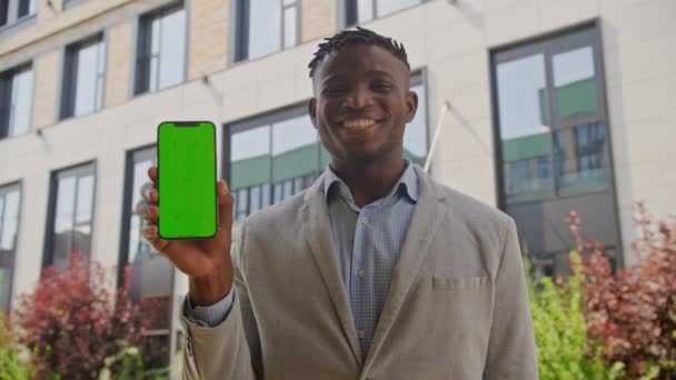 Черный Человек Держит Зеленый Экран Сотового Телефона Смотрит Камеру Африканский — стоковое видео