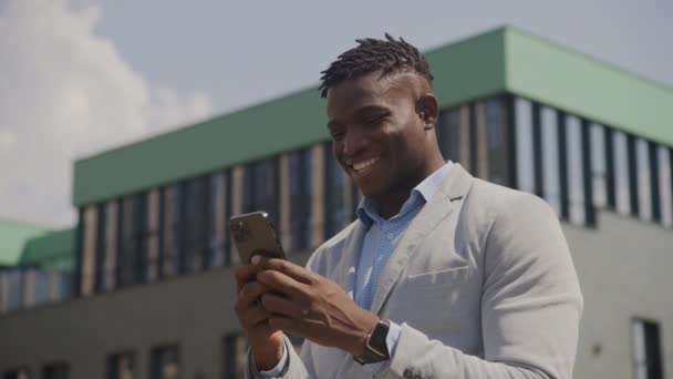 Черный Человек Пишет Смс Мобильный Снаружи Афроамериканский Бизнесмен Печатает Смартфоне — стоковое видео