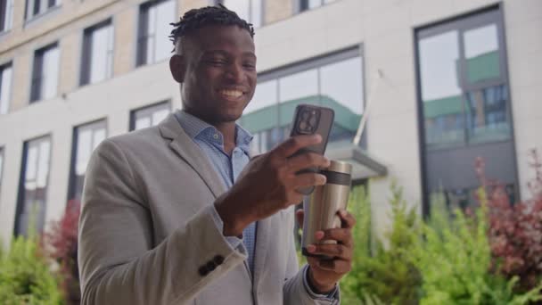 Sonriente Hombre Negro Mensajes Texto Teléfono Celular Beber Café Fuera — Vídeos de Stock