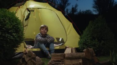 Dışarıda çadırda oturan çocuk. 4K