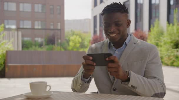 Homme Noir Jouant Jeu Vidéo Smartphone Assis Dans Café Plein — Video