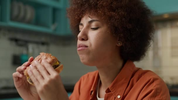 アフリカ系アメリカ人女性チューイングバーガー クローズアップ おいしいハンバーガー スローモーション ハンドヘルドカメラを食べる黒人女性 4Kについて — ストック動画