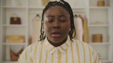 Siyah kadın avuç içi hareketi yapıyor. Kızgınlığını, inançsızlığını, bıkkınlığını, utancını ya da can sıkıntısını kameraya bakarak ifade eden bir kadın. 4K