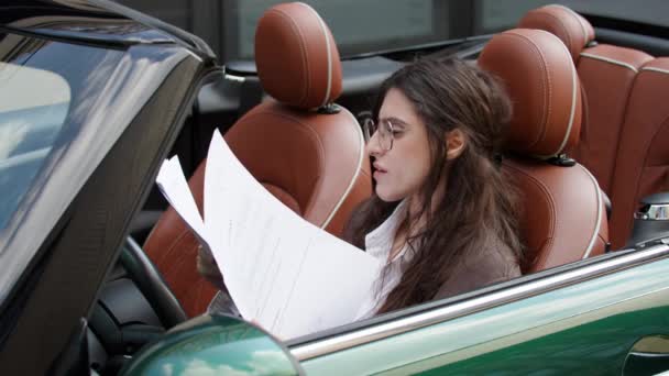 Επιχειρηματίας Κοιτάζοντας Μέσα Από Έγγραφα Που Κάθονται Στο Αυτοκίνητο Γυναίκα — Αρχείο Βίντεο