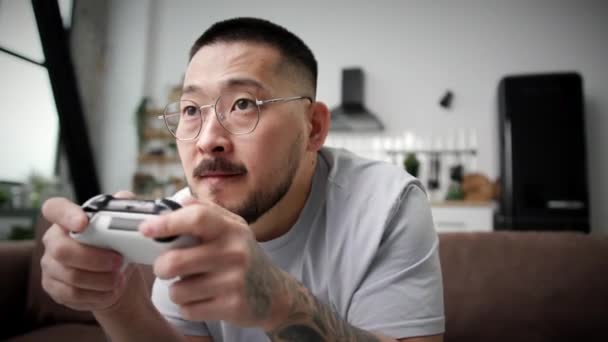 Hombre Jugando Videojuegos Sosteniendo Joystick Cerca Hombre Asiático Jugando Juegos — Vídeo de stock