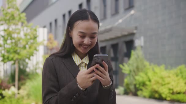 Mujer Alegre Mensajes Texto Smartphone Pie Fuera Mujer Negocios Asiática — Vídeos de Stock